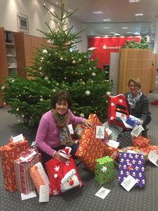 Bild: selbst der Vorstand (Vorsitzende Angelika Steinhoff links, 2. Vorsitzende Andrea Hesse rechts) der Mutter-Kind-Hilfe strahlte angesichts der wundervoll verpackten Geschenke. Rechtzeitig vor Weihnachten wurden sie dem Christkind übergeben. 